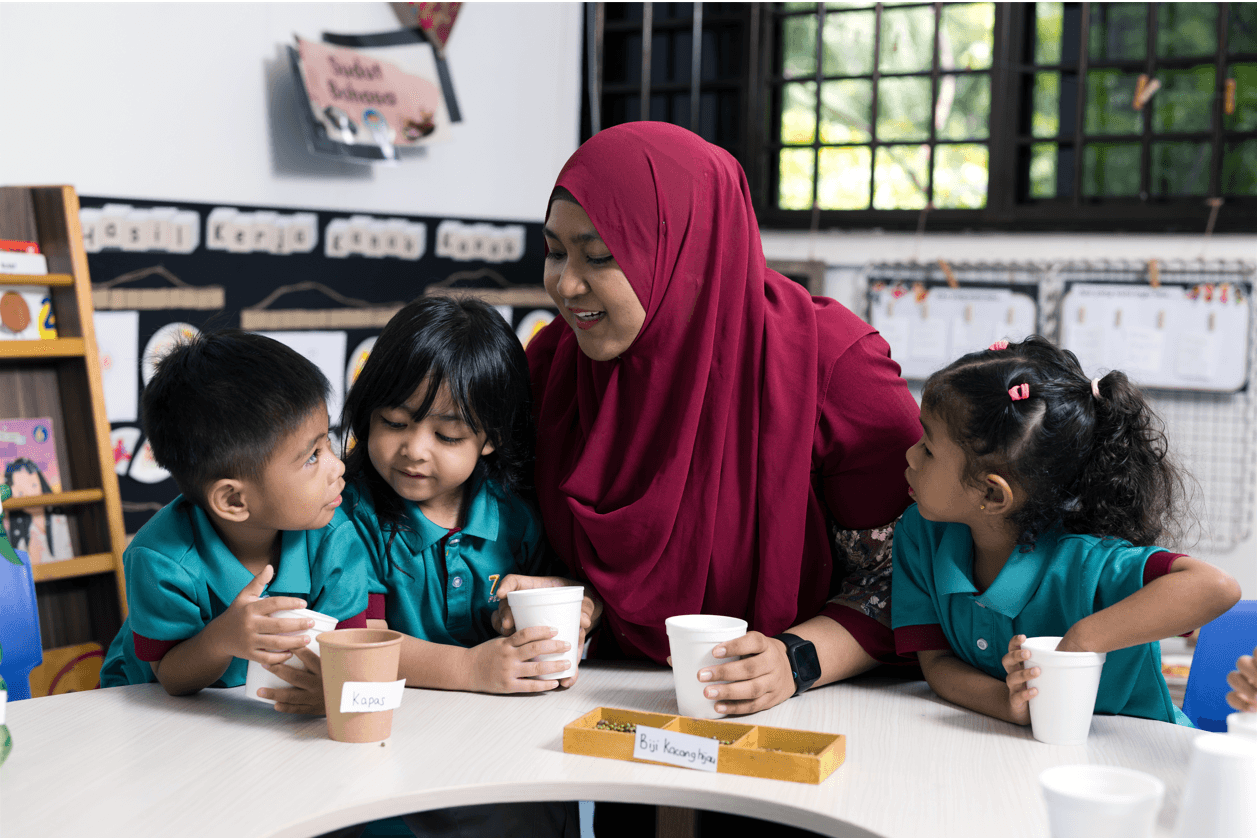 teacher teaching students how to share green beans among 5 cups